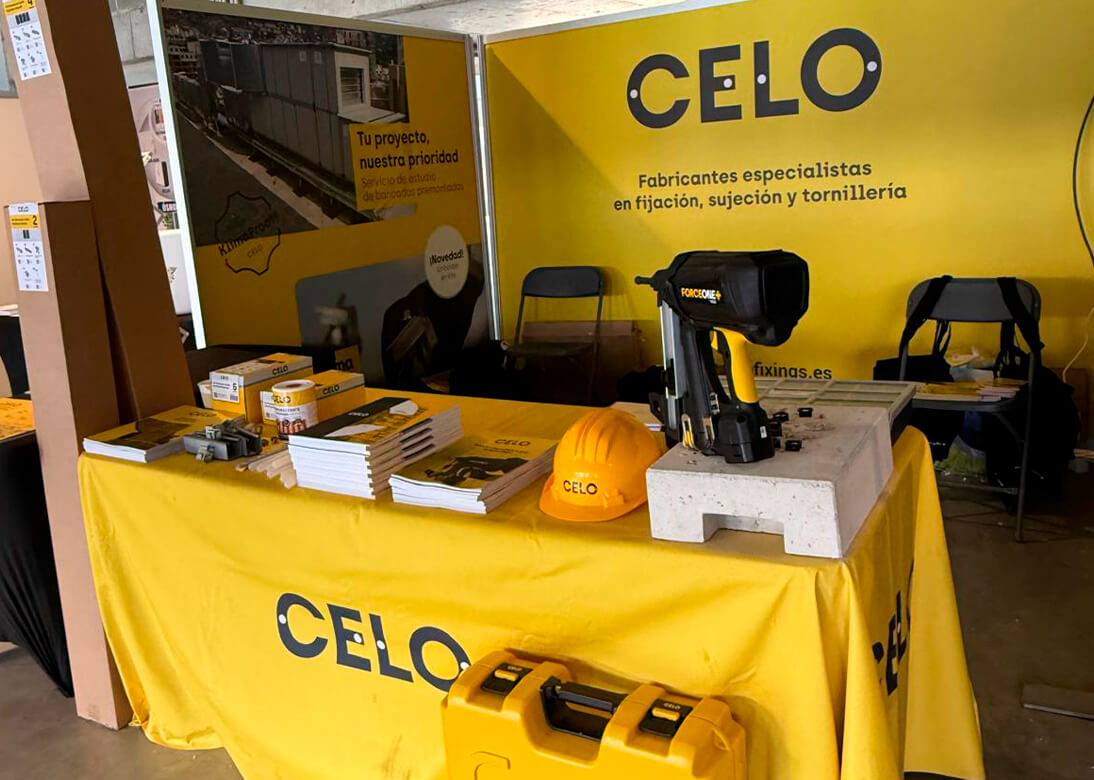 Stand de CELO en la feria Auna Partner Day con mostrador amarillo con una pistola de clavos y otros productos