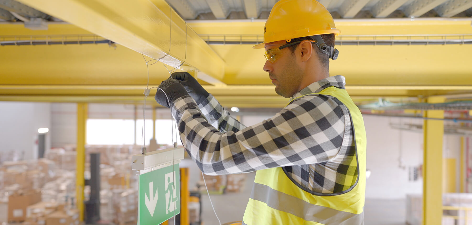Técnico instalando un sistema de fijación suspendida en una estructura metálica