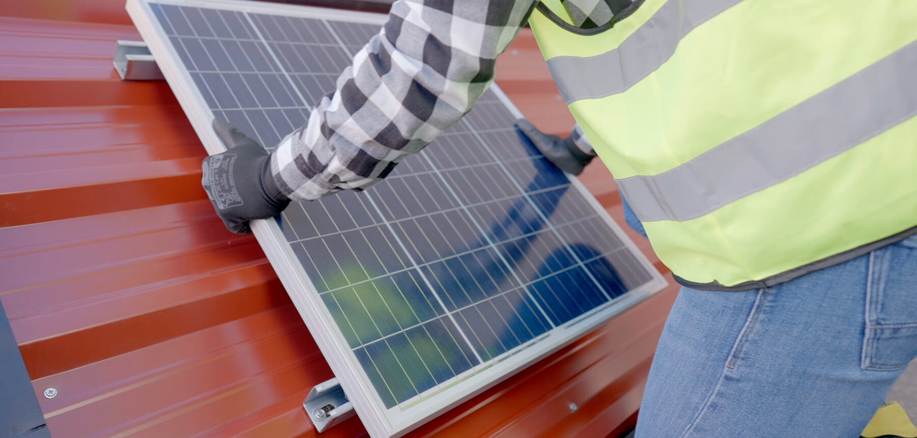 instalador montando un panel solar sobre un tejado de chapa con sistema de sujeción